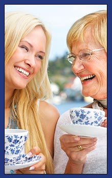 photo of smiling two women having tea